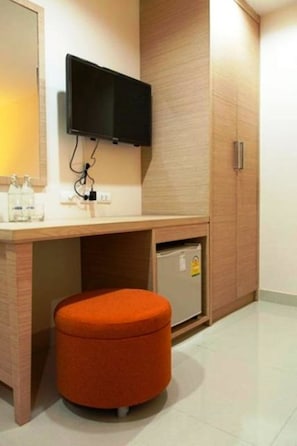 A modern hotel room with a wooden desk, a television mounted above it, and a small refrigerator under the desk. - Gateway Hotel Pratunam (Bangkok)