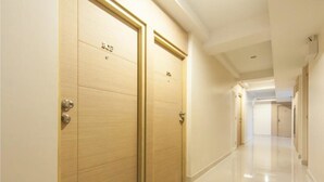 Un pasillo con puertas de madera y un suelo brillante.