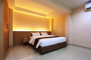 A modern hotel room with a large bed, a bedside table, and a wall-mounted air conditioner. - Gateway Hotel Pratunam (Bangkok)