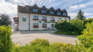 A two-story hotel with a traditional architectural style, featuring a brick facade and multiple windows. - Lohmann's Kapeller Hof (Langenfeld)