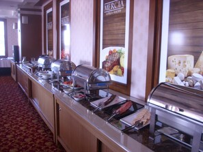 Ein Buffet mit verschiedenen Speisen und einem Schild mit der Aufschrift 'Mercia Hotels & Resorts'.