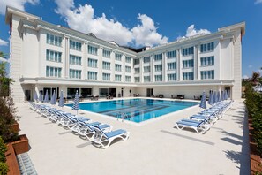 A large hotel with a swimming pool, sun loungers, and umbrellas. - Mercia Hotels & Resorts (Istanbul)