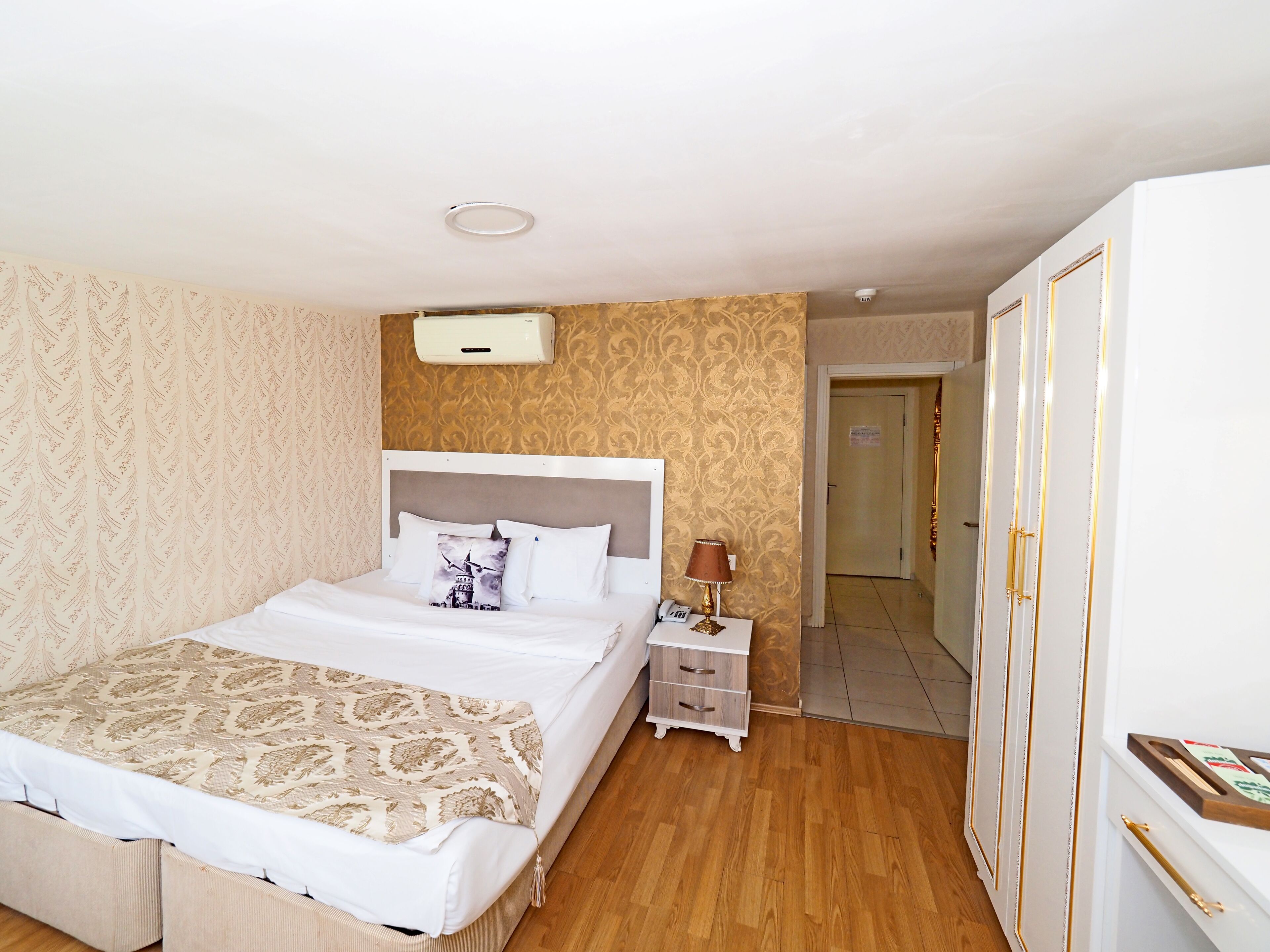 A neatly arranged bedroom with a bed, bedside table, lamp, and wardrobe.