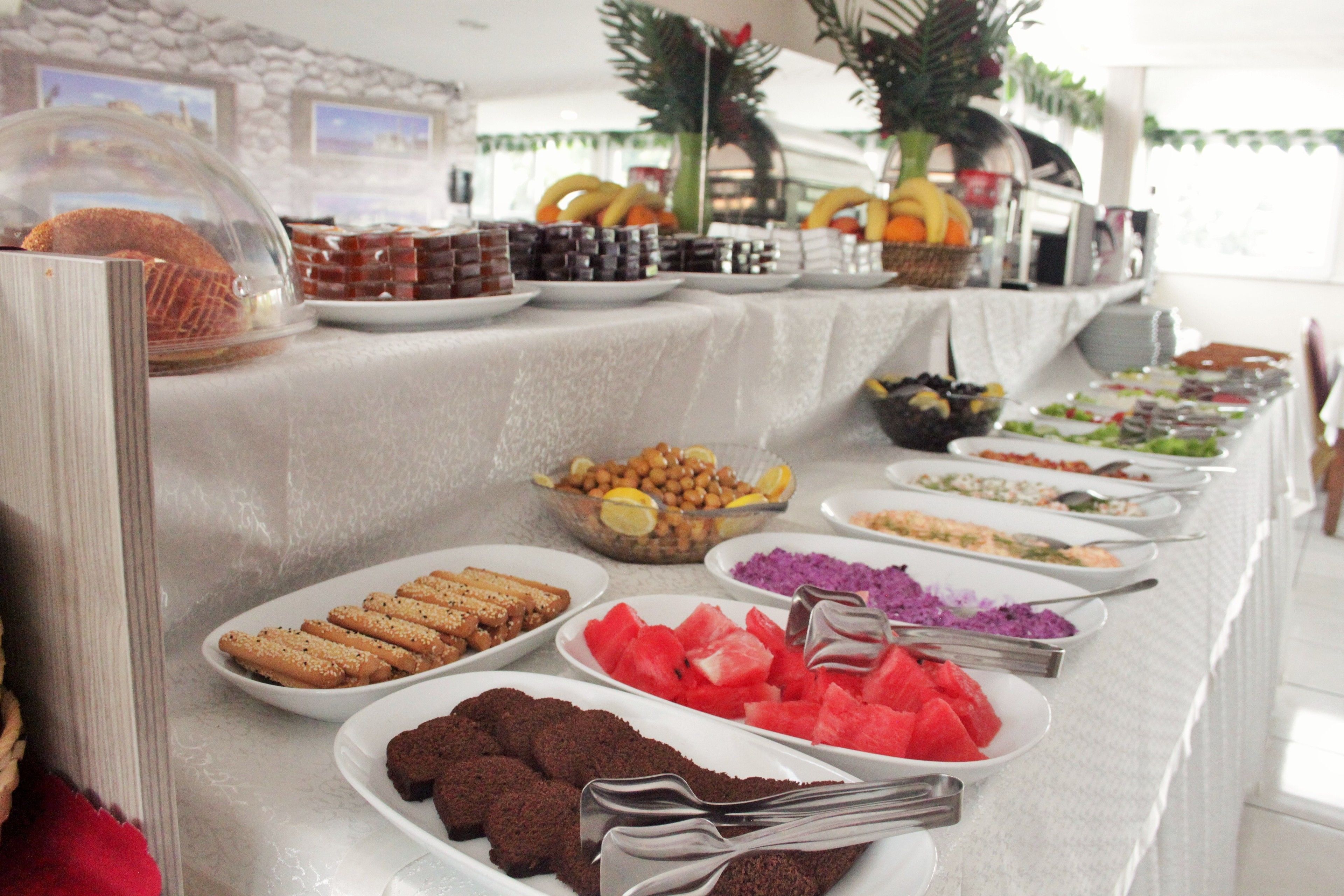 A buffet with various food items including cookies, watermelon, and other dishes.