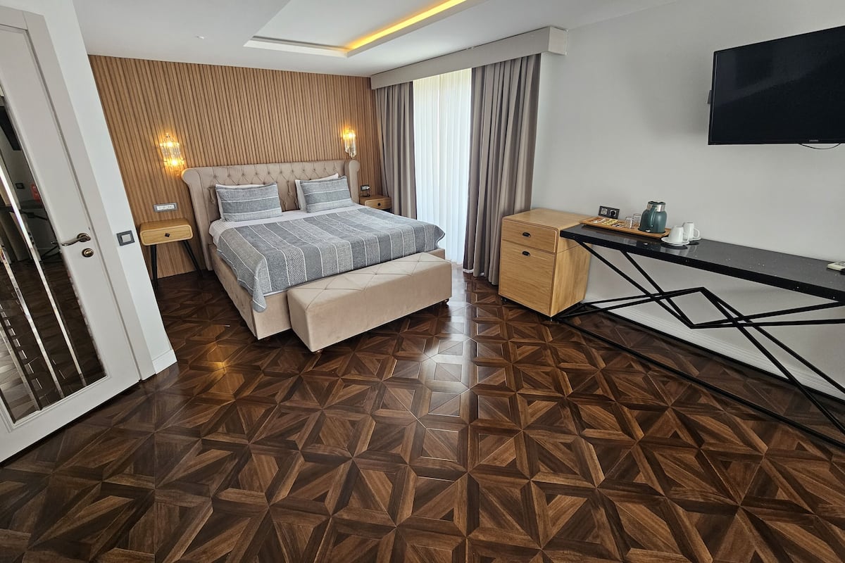 Una habitación de hotel moderna con una cama grande, un escritorio y una televisión.