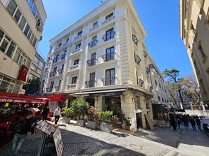 A hotel with a classic facade, multiple balconies, and a cobblestone street in front. - Anthemis Hotel (Istanbul)