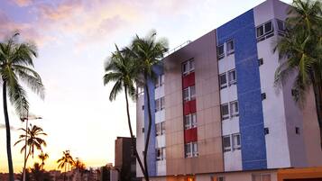 Stunning hotel building with a modern design, set amidst lush palm trees.