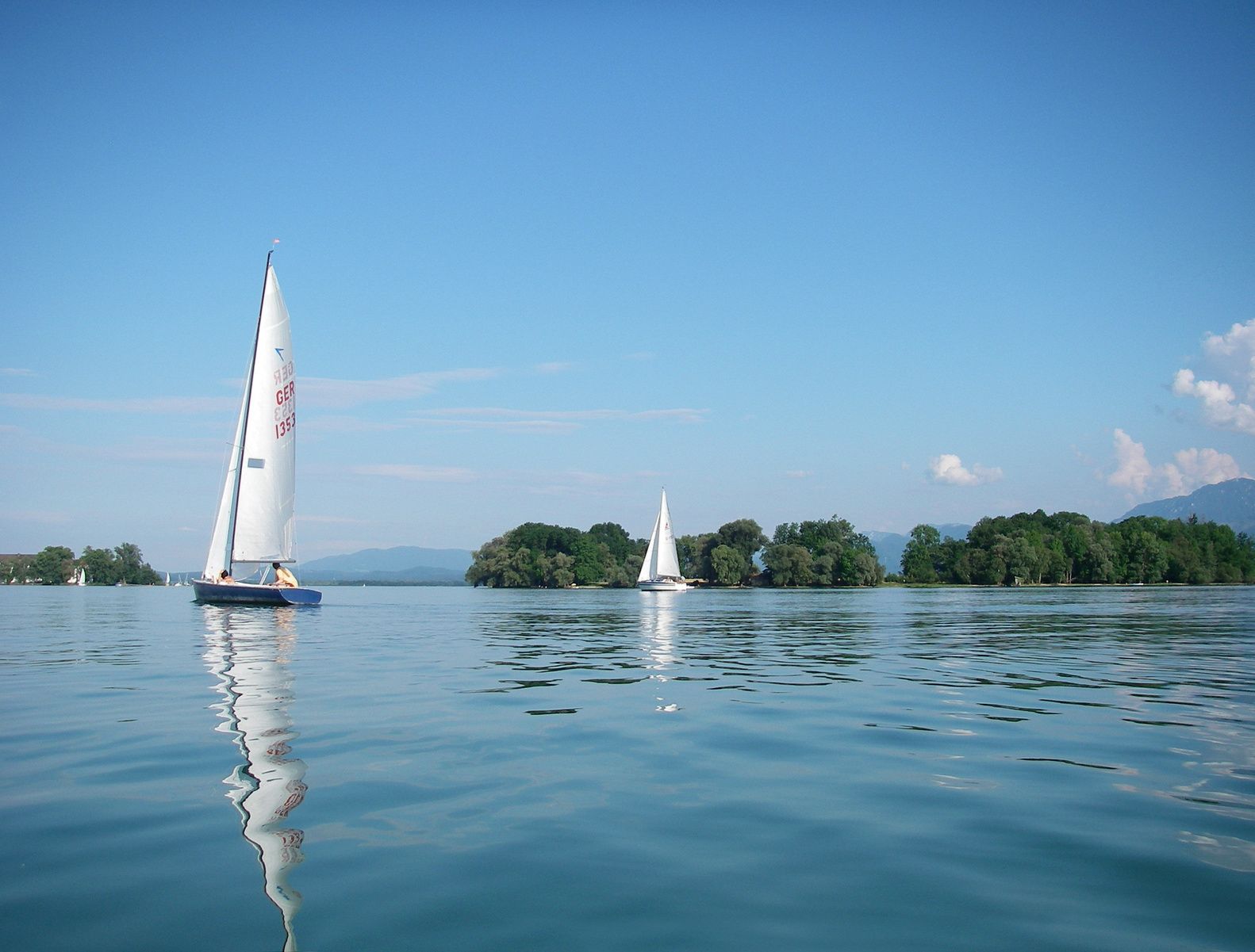 A calm lake with sailboats.