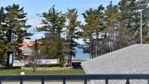 A view of a building with a tiled roof, a parking lot, and a sign that reads "Old Mack Point". - Lighthouse View Motel (Mackinaw City)