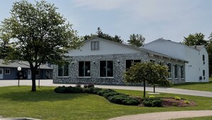 A two-story building with a stone facade and large windows. - Lighthouse View Motel (Mackinaw City)