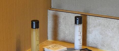 A small table with two bottles of liquid, a box, and a packet of wipes.