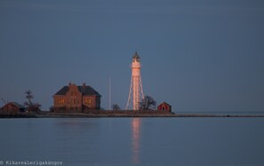 Un faro con una torre alta y esbelta, y una casita cerca.
