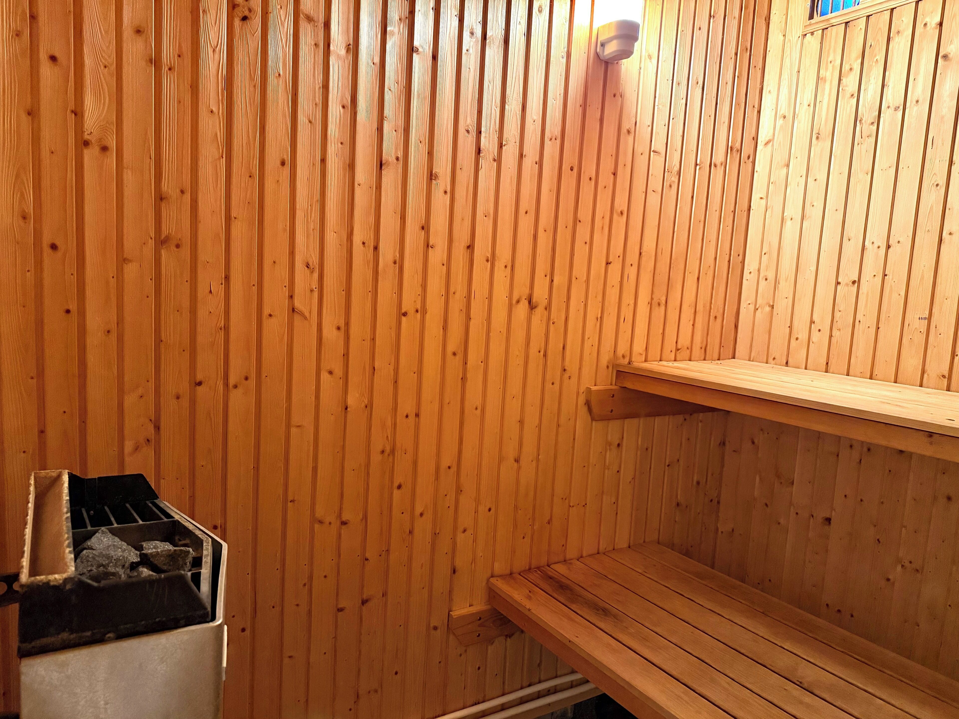 A sauna with wooden walls and a bench.