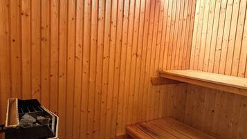 A sauna with wooden walls and a bench.