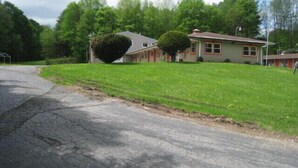 A two-story house with a well-maintained lawn and a driveway. - The Rome Motel (Rome)