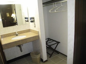 A bathroom with a sink, mirror, and towel rack.