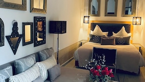 Una camera da letto con un letto grande, un divano e diversi specchi a parete.