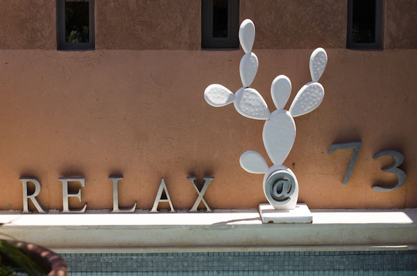 A building with a sign that reads "RELAX 73" and a cactus sculpture. - Dar 73 (Marrakech)