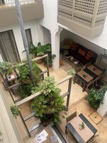 Spazio interno su più livelli con zona pranzo, posti a sedere e piante in vaso.