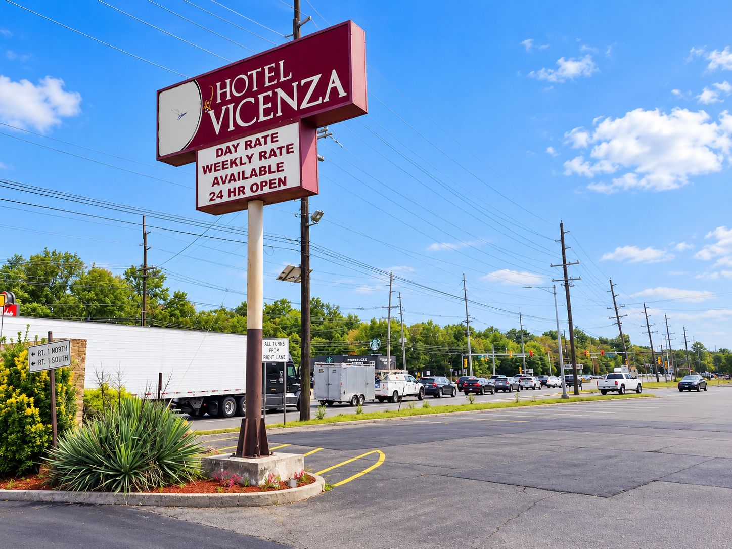 A hotel sign with 'HOTEL VICENZA' and 'DAY RATE WEEKLY RATE AVAILABLE 24 HR OPEN' text.