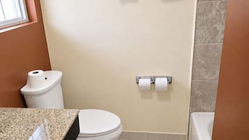 Un baño con inodoro, lavamanos, toallero y un cartel que prohíbe tirar pañales húmedos y productos de higiene femenina.