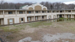 Un motel à étages avec une cour intérieure et un petit étang.