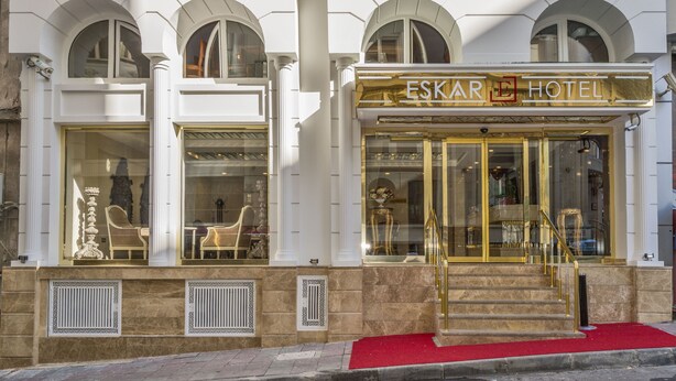 The exterior of the Eskare Hotel with a red carpet entrance, large glass windows, and classical architectural elements. - Escardin Hotel (Istanbul)