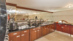 A buffet setup with multiple food stations, a wooden counter, and a tiled floor. - Escardin Hotel (Istanbul)