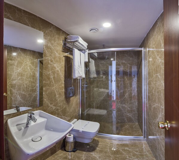 Une salle de bain moderne avec une douche à parois de verre, un lavabo et des toilettes.