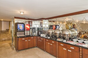 A buffet setup with a coffee machine, hot food dispensers, and a variety of dishes. - Escardin Hotel (Istanbul)