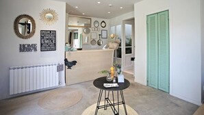 Zona de recepción con mostrador, decoración en la pared y una puerta verde.