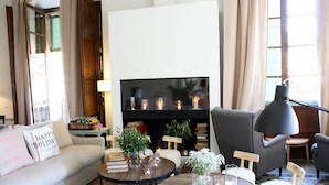 Una sala de estar acogedora con un sofá, sillones, una mesa de centro y una chimenea.
