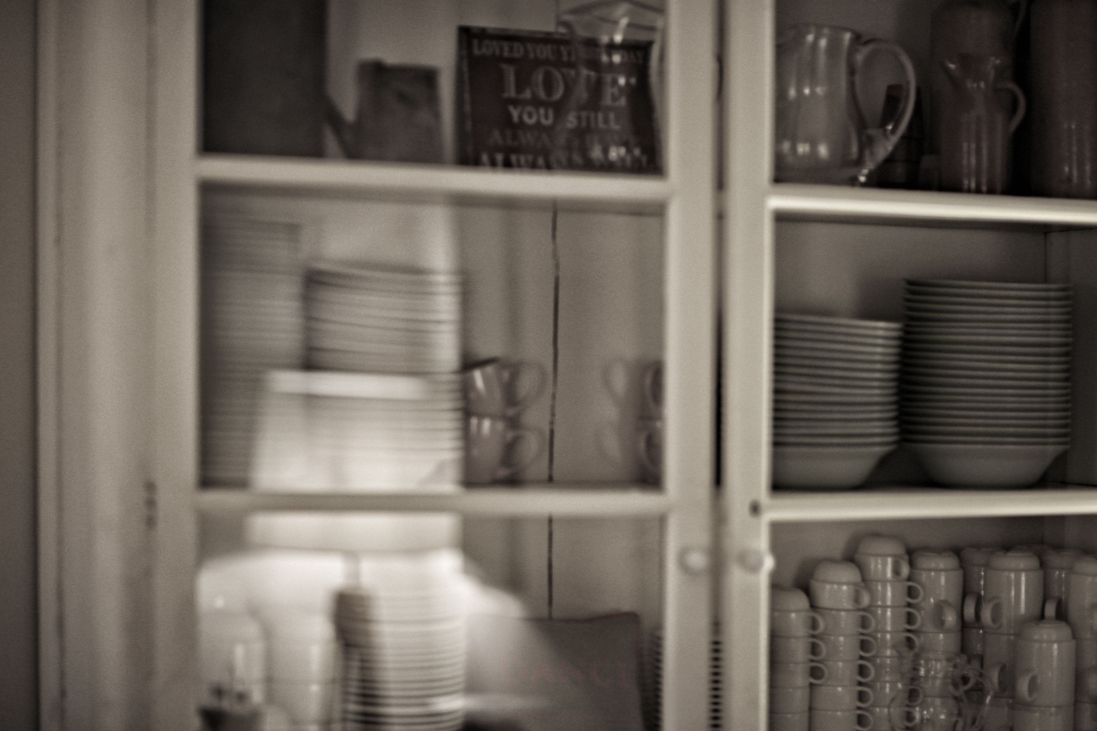 A kitchen with shelves stocked with plates, bowls, and cups.