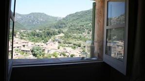 Una ventana con vistas a un pueblo y montañas.
