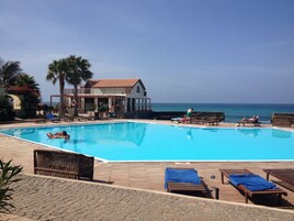 Una piscina al aire libre, tumbonas