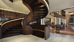 Ein modernes Interieur mit einer Wendeltreppe, einer geräumigen Lobby und einer Sitzecke.