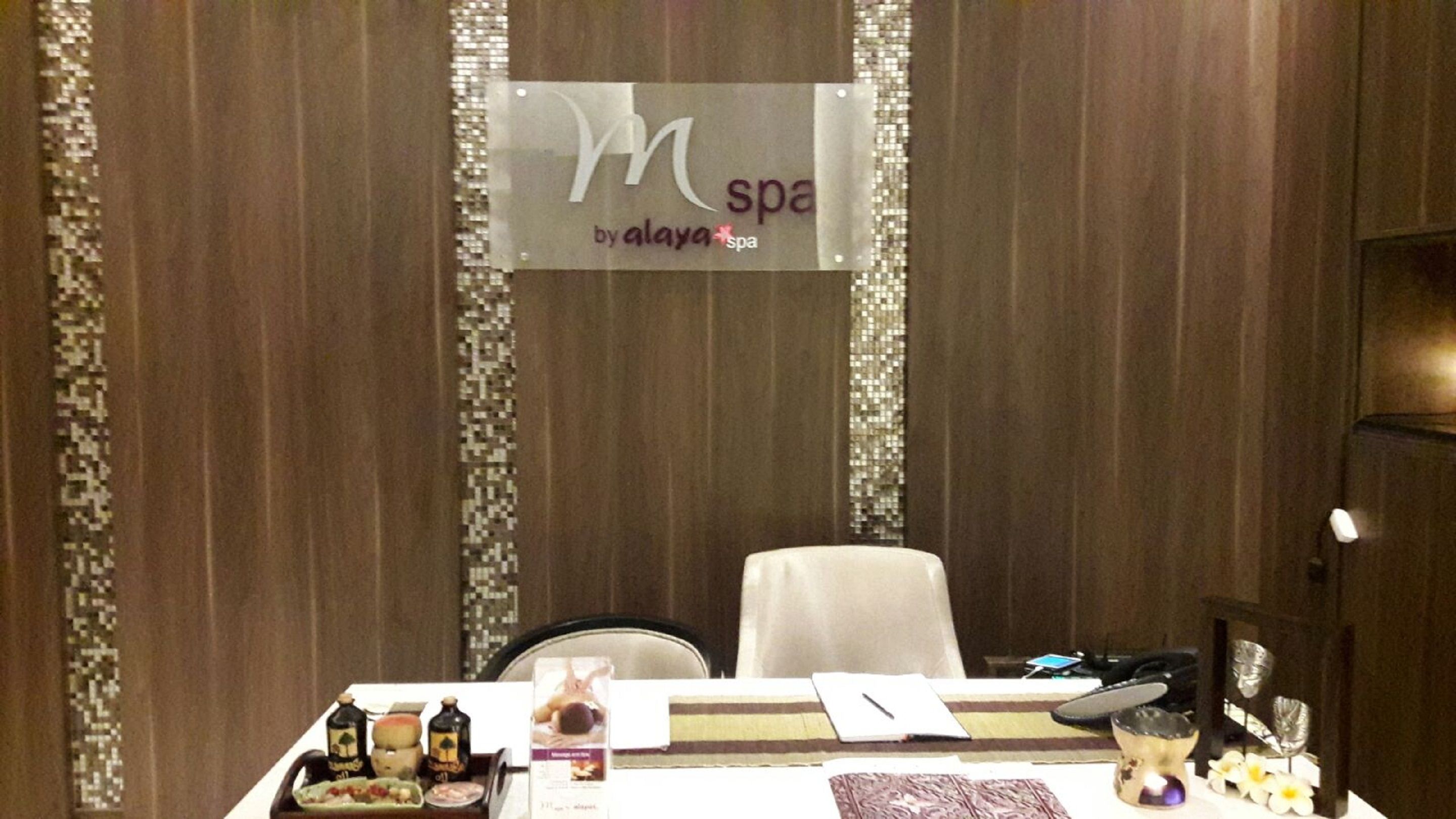 A hotel reception desk with a sign reading "M spa by alaya spa".