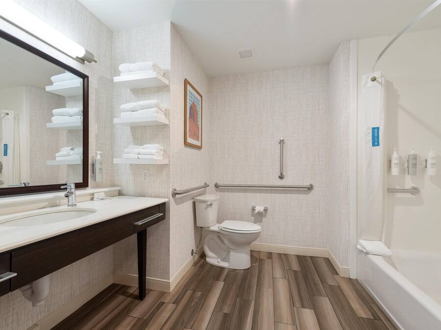 A modern bathroom with a sink, toilet, and shower.