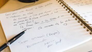 A spiral-bound notebook with handwritten notes and a pen.