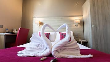 A hotel room with a bed, a desk, a chair, and a wardrobe.