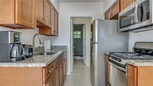 Apartamento, 2 quartos | Cozinha privada | Cafeteira/chaleira, geladeira grande, micro-ondas, cooktop