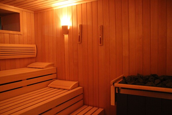 A sauna with wooden benches and a bench with a backrest.