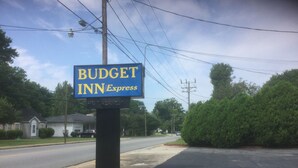 Une enseigne indiquant « Budget Inn Express » avec une affiche « Complet ».