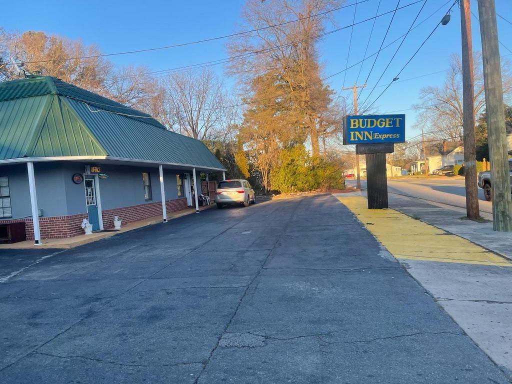 A building with a green roof and a sign for 'BUDGET INN Express' on the right.