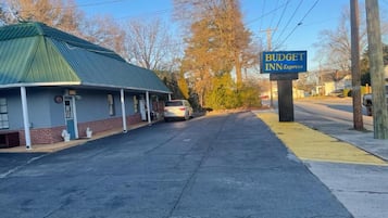 A building with a green roof and a sign for 'BUDGET INN Express' on the right.