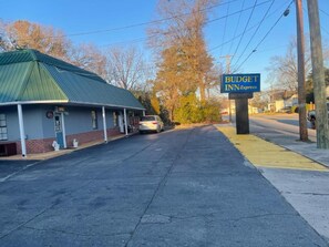 A building with a green roof and a sign for 'BUDGET INN Express' on the right. - Budget Inn Express (South Hill)
