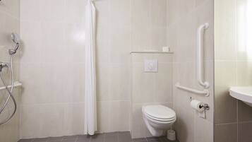 A bathroom with a shower, toilet, and grab bars.