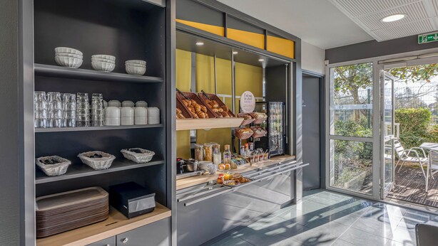 A breakfast bar with various food items and glassware.