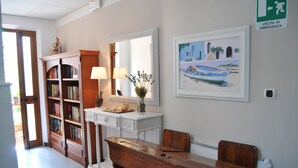 A room with a wooden desk, a white dresser, a bookshelf, a mirror, and a painting on the wall. - Hotel Villa Rosa (Sestri Levante)