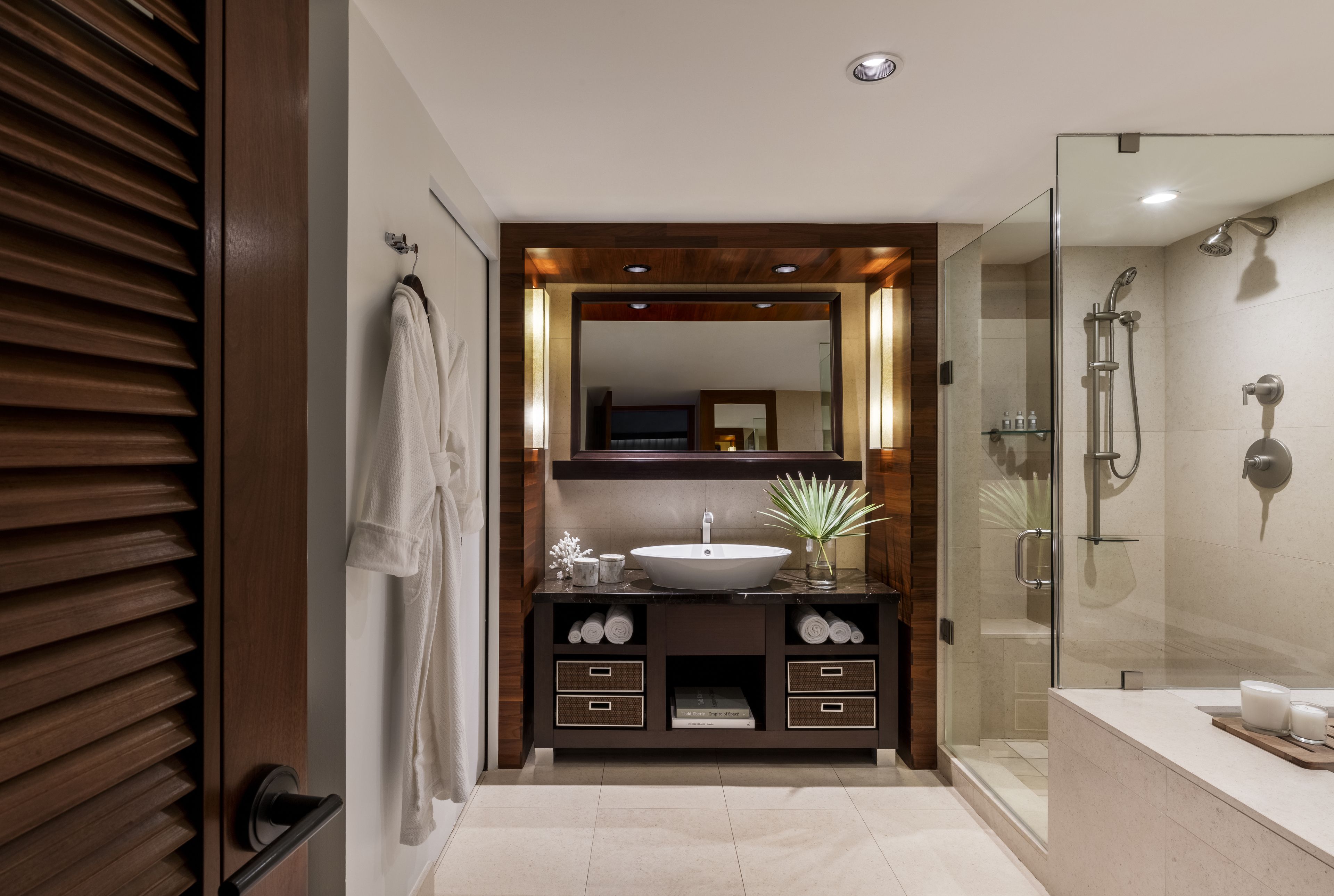 A modern bathroom with a large mirror, a sink, and a shower.